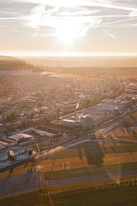 Aerial view of a city at sunset with snow-covered fields and shadow effects, Althengstett, Calw district, Germany