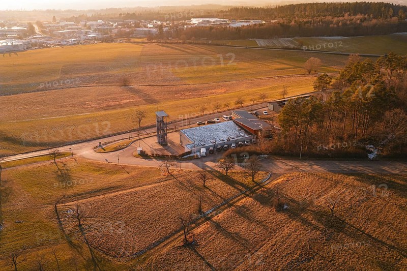 Aerial view of a landscape in evening light with fire station surrounded by fields and trees, Althengstett, Calw district, Germany