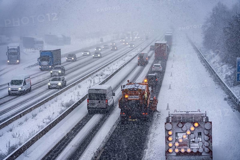 The onset of winter in North Rhine-Westphalia, heavy snowfall, A3 motorway near Hilden, near Ohligser Heide rest area, snow-covered roads, winter service of the motorway maintenance department with stray and clearing vehicles, traffic is sometimes only stalled, North Rhine-Westphalia, Germany