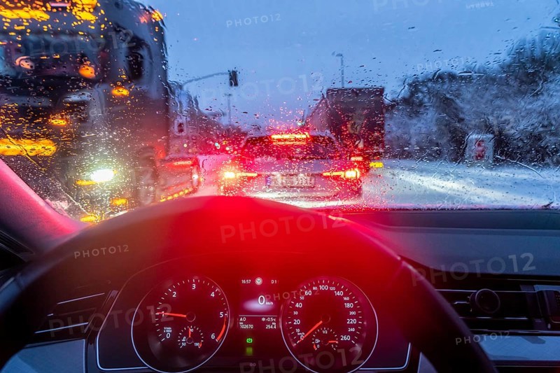Driving in winter, in snow, rain, rear lights, brake lights, speedometer, cockpit