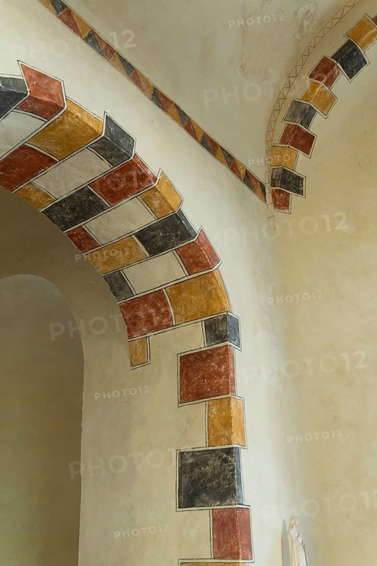 Painted arch in red, yellow and black. St Aignan's Church of Begues. Allier department. Auvergne Rhone Alpes. France. Europe