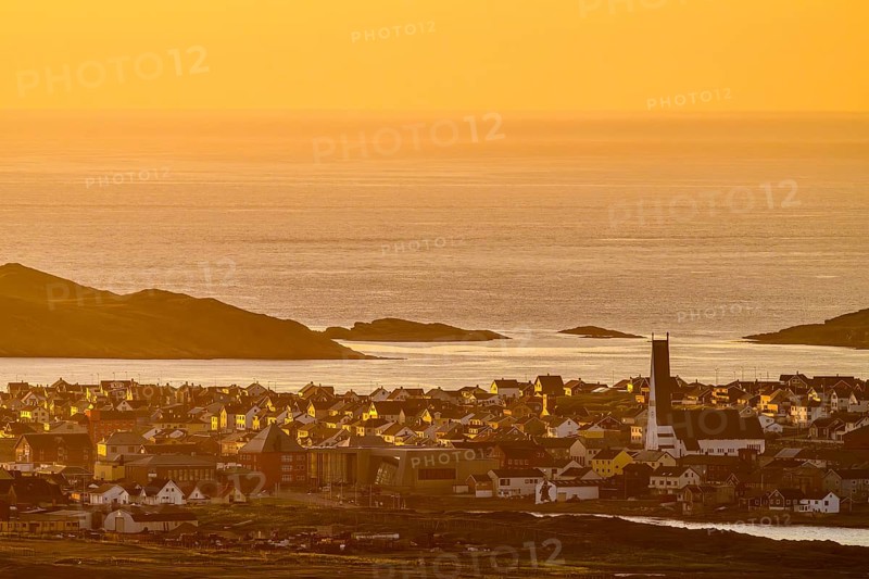View of the city of Vardø from Mount Domen, sea at sunset with golden sky and calm atmosphere, Kiberg, Finnmark, Norway