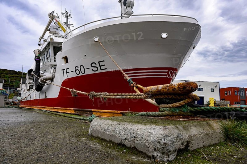 Large fishing boat fishing vessel in harbor secured by thick ropes cords on a massive Hadfenbollard, Berlevåg, Finnmark, Norway