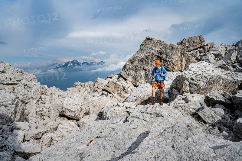 Mountaineers between large boulders, rocky mountain landscape, Via Ferrata SOSAT via Ferrata, in the background mountain peaks of the Adamello GroupBrenta Mountains, Trentino, Italy