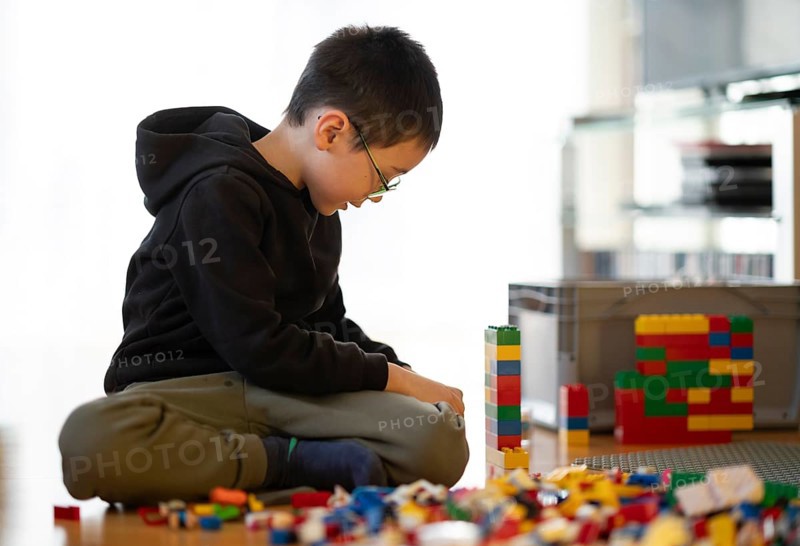 Boy, 6 years, glasses, multi-ethnic, plays with Lego, concentrates, constructs, builds, Stuttgart, Baden-Württemberg, Germany