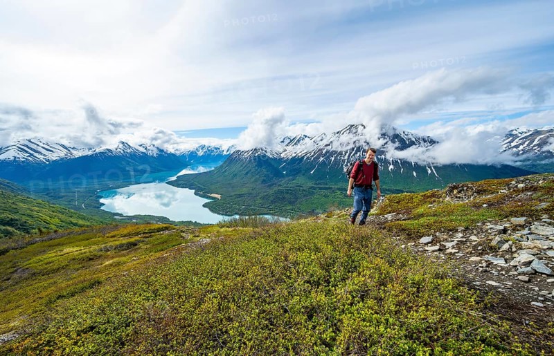 Climbers on a hiking trail, Slaughter Ridge Trail, view of snowy mountains and turquoise lake Kenai Lake, Cooper Landing, Kenai Peninsula, Alaska, USA