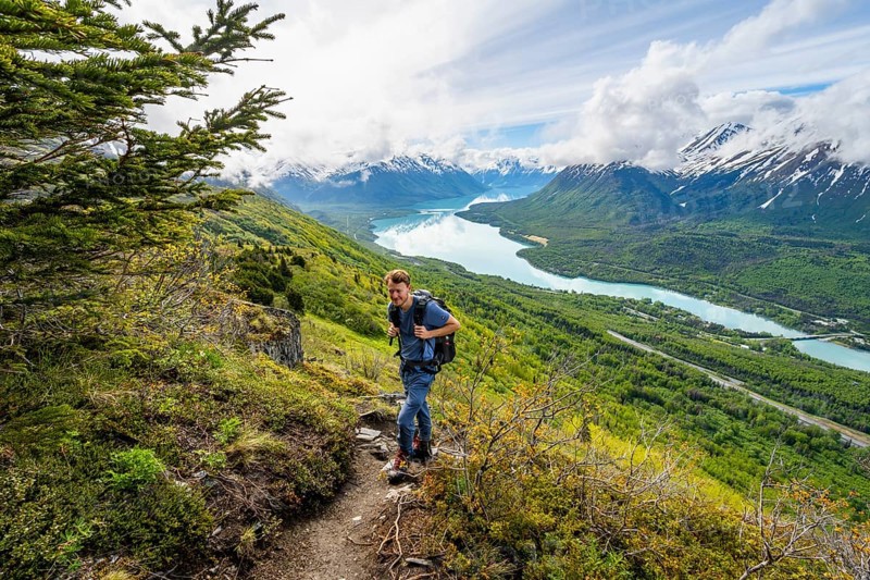 Climbers on a hiking trail, Slaughter Ridge Trail, view of snowy mountains and turquoise lake Kenai Lake, Cooper Landing, Kenai Peninsula, Alaska, USA
