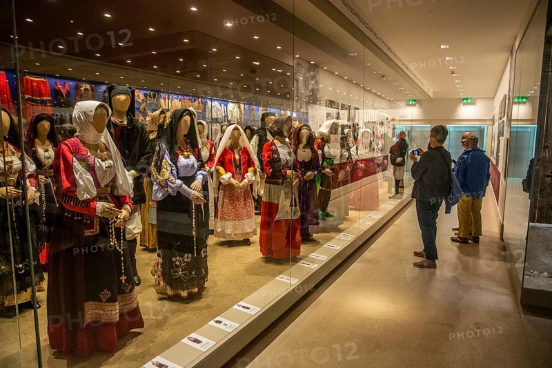 Sardinian folk costumes and visitors in the museum in Nuoro, Sardinia, Italy