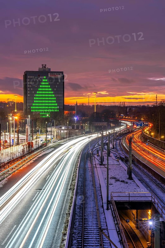 Autobahn A40, Ruhrschnellweg, between Essen and Mülheim an der Ruhr, evening traffic in winter, former, now vacant Stinnes high-rise building, at the Rhine-Ruhr Center, showing a green Christmas tree from illuminated windows at Christmas time, North Rhine-Westphalia, Germany