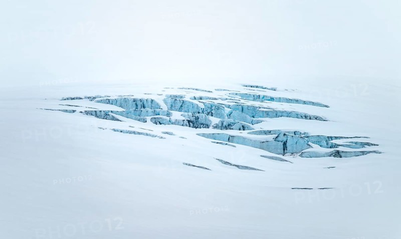 Smooth white snowy area on the glacier broken by crevasses with blue rugged glacial ice, detail, Exit Glacier, Kenai Peninsula, Alaska, USA