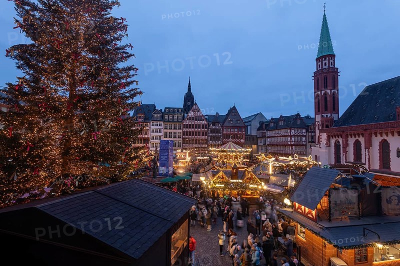 December 22, 2025, View from a window inside the Roemer looking down at the Frankfurt Christmas Market on Roemerberg at twilight. Festive lights and stalls fill the historic square below, Frankfurt, Hesse, Germany