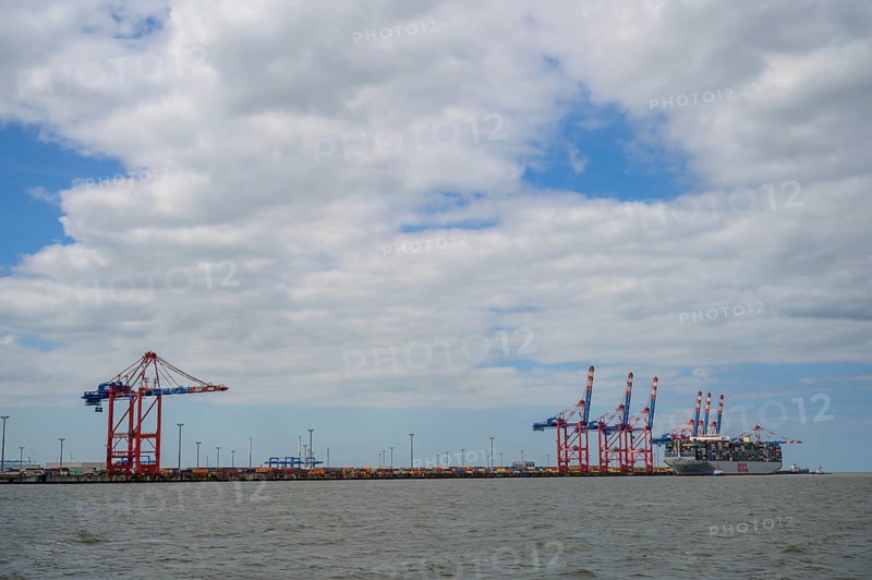 The container ship OOCL Germany with 59 m width and 400 m length of one of the largest container ships in the world maneuvers between cranes in Jade Weser Port, Wilhelmshafen, Jade Bay, Lower Saxony, Germany