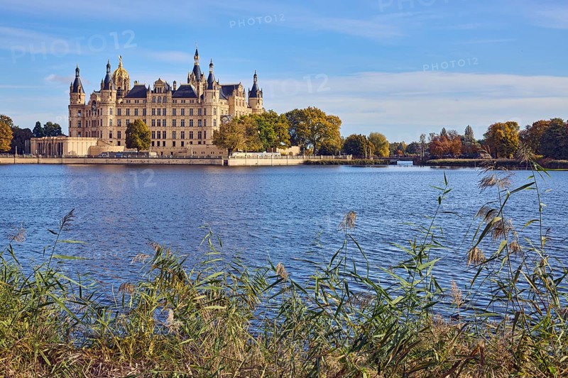 Castle, lake Burgsee, reed (Phragmites australis), trees, bushes, water surface with small waves, blue sky, cumulus clouds, cirrostratus clouds, Schwerin, state capital, independent city, Mecklenburg-Vorpommern, Germany