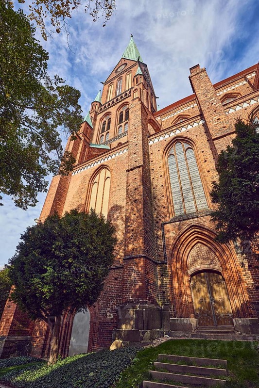 Schwerin Cathedral, St. Mary's Cathedral in Schwerin - Ev. -Luth. Schwerin cathedral, tower, brick Gothic, neo-Gothic style, entrance door, stained-glass window, trees, branches, blue sky, cumulus clouds, street Am Dom, Schwerin, state capital, district-free city, Mecklenburg-Western Pomerania, Germany