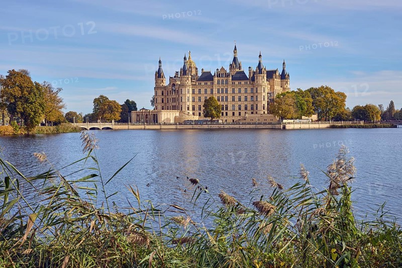 Castle, lake Burgsee, reed (Phragmites australis), trees, bushes, car bridge and pedestrian bridge, water surface with small waves, blue sky, cumulus clouds, cirrostratus clouds, Schwerin, state capital, independent city, Mecklenburg-Vorpommern, Germany