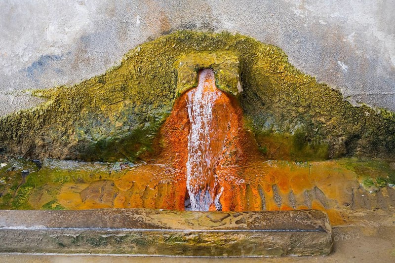 Rust-brown water flows from a spring in a concrete wall surrounded by eroded mineral deposits, mineral spring, Bolnissi, Katharinenfeld, Lower Kartli region, Kwemo Kartli, Georgia