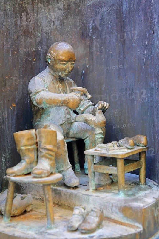 Shoemaker making shoes at Bonifatius Stirnberg's guild fountain 1983, modern art, bronze sculpture, city history, historical profession, shoemaker, hammering, processing, manufacturing, hammer, tool, guild fountain, Reutlingen, Swabian Jura, Baden-Württemberg, Germany