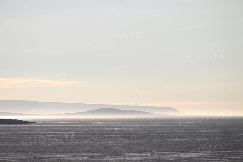 Vardø, Finnmark, Norway, Atmospheric seascape with soft lighting at sunset and silhouetted island background, Vardø, Finnmark, Norway