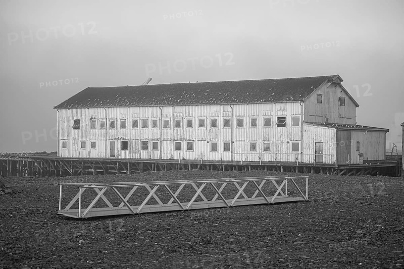 Elongated façade of an old port building in a foggy coastal atmosphere, Vardø, Finnmark, Norway
