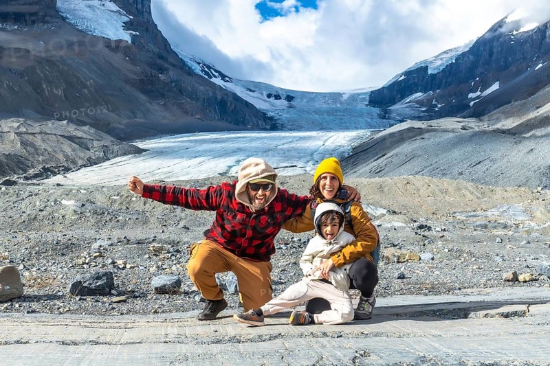 Happy family posing for a photo in front of the breathtaking athabasca glacier in jasper national park, embracing the beauty of the canadian rockies during a memorable vacation