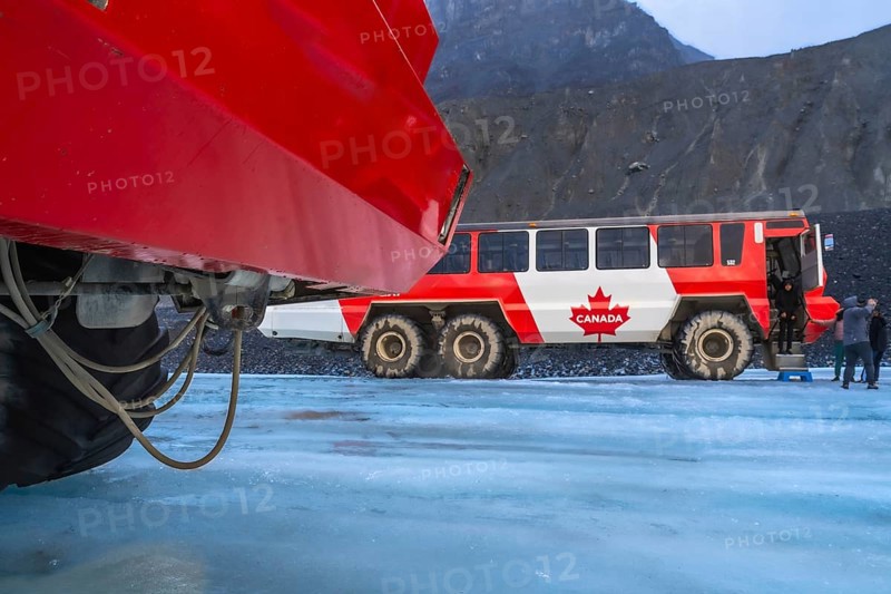 Red ice explorer buses standing on the athabasca glacier in the columbia icefield area of jasper national park in the canadian rockies of alberta, canada, offer tourists a unique experience