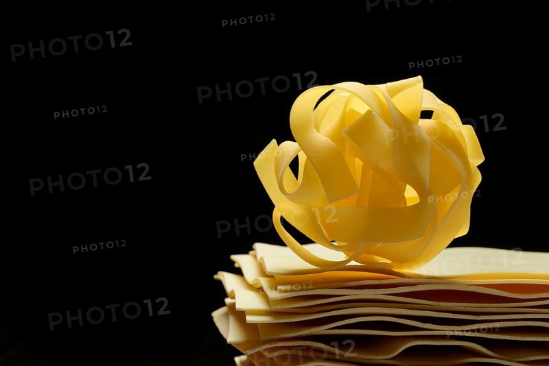 Uncooked lasagna leaves and fettuccine, noodle nest