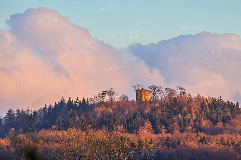 Hill with the tower of Diedrichsburg, surrounded by forests, under a pastel-colored sky in the morning light, Meller Mountains, Melle, Lower Saxony, Germany