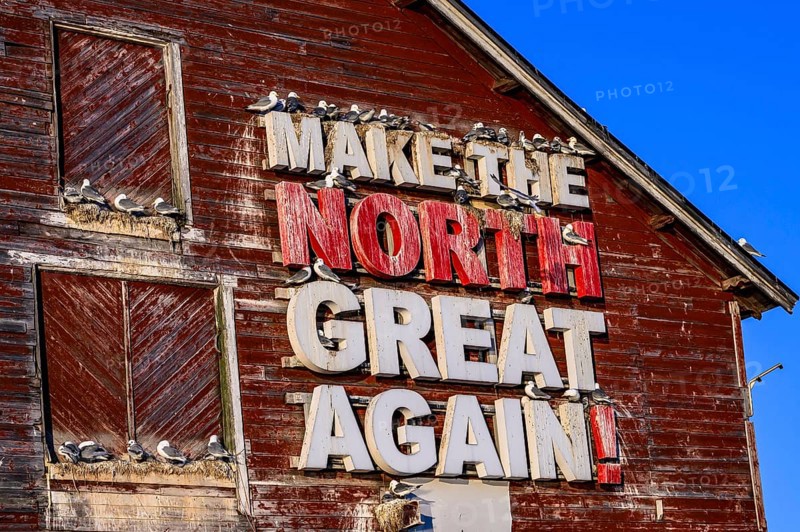 Red fishing building with the inscription Make the North great again at Vardö harbour, Vardø, Finnmark, Norway