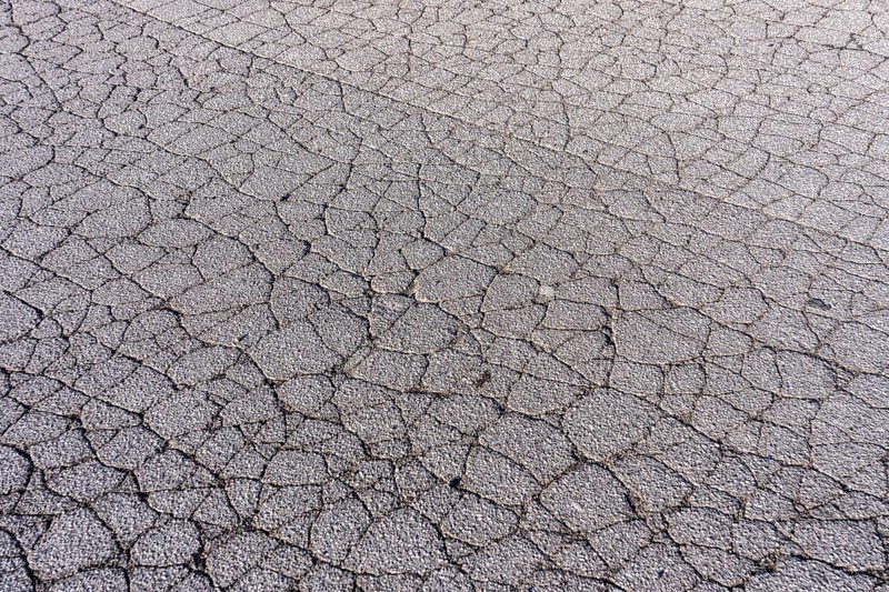 Asphalt surface, floor, with many small cracks, roadway, parking lot