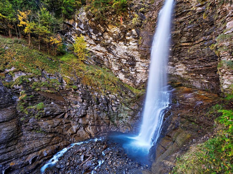 Diesbach waterfall in autumn-colored surroundings, Linthal, Klausenpass, Canton of Glarus, Switzerland