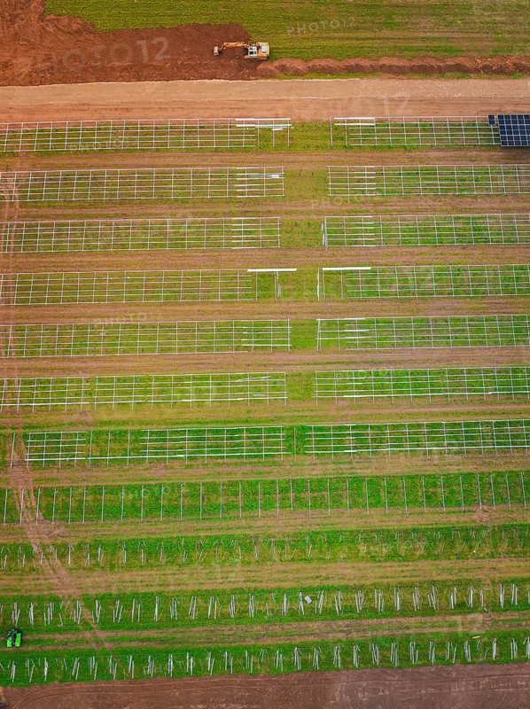 Aerial view of green fields with beginning solar plant construction and agricultural patterns, energy transition, construction of PV open space, Baden-Württemberg, Germany