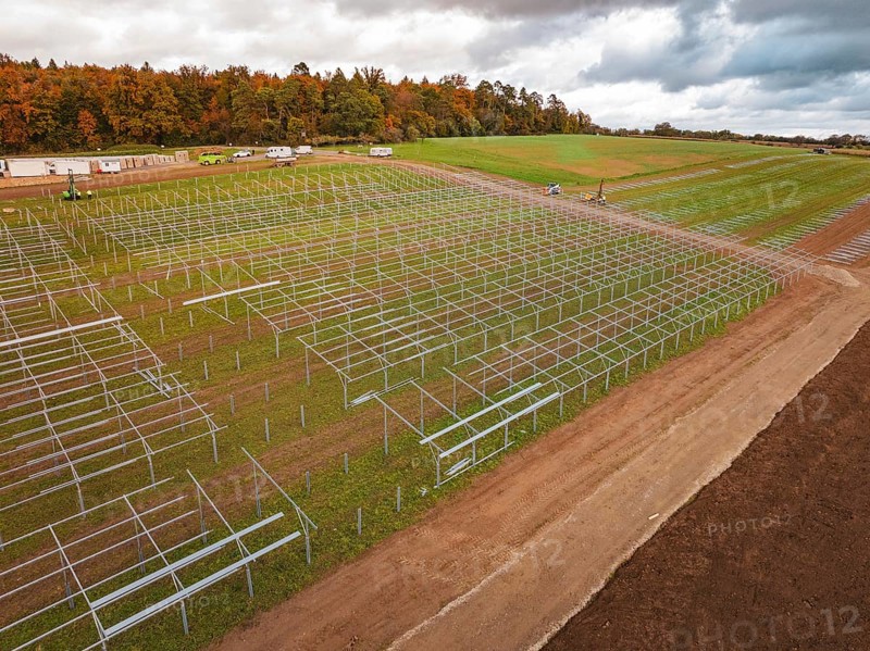 Racks for solar panels spread over an extensive landscape under cloudy sky, Energiewende, construction of PV open space, Baden-Württemberg, Germany