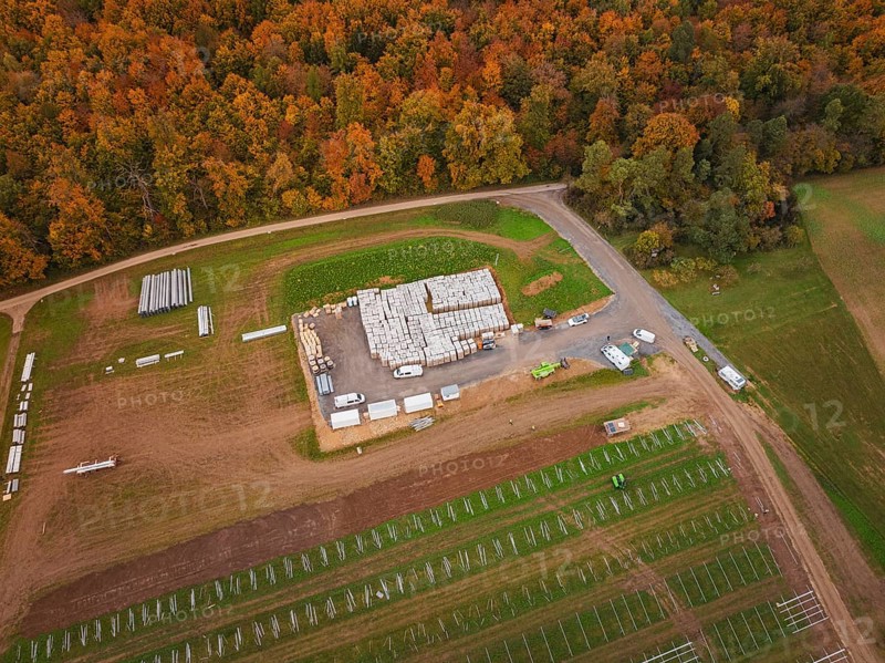 Large-scale warehouse with building materials and vehicles, surrounded by autumn landscape and fields, energy transition, construction of PV open space, Baden-Württemberg, Germany