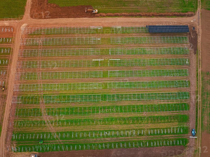 Large-scale solar frame construction on a field, surrounded by farmland seen from the air, energy revolution, construction of PV open space, Baden-Württemberg, Germany