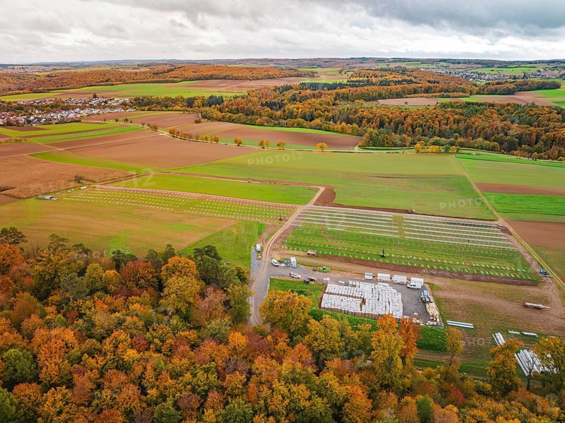 Autumn panorama with colorful foliage, fields and a small village in the distance, Energiewende, construction of PV open space, Baden-Württemberg, Germany