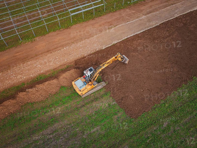 Aerial view of an excavator working a field and moving soil, Energiewende, construction of PV open space, Baden-Württemberg, Germany