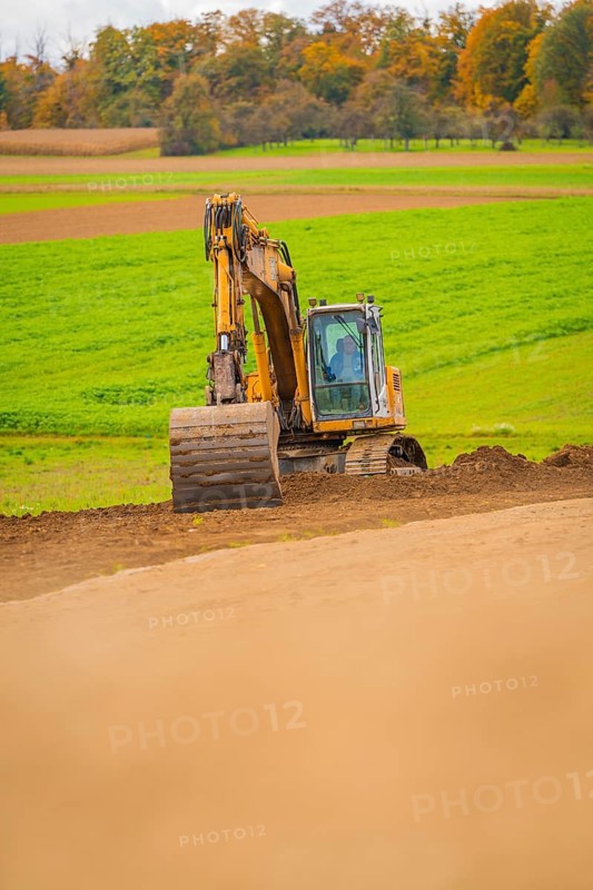 Excavator works on a hill in a green field in autumn, energy revolution, construction of PV open space, Baden-Württemberg, Germany