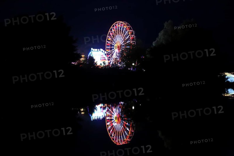 Fairground in Ulm Friedrichsau at night, folk festival, hustle and bustle, fair, Ferris wheel, amusement park, amusement attraction, ride, artificial light, darkness, reflection in natural lake, Ausee, Ferris wheel, Ulm, Baden-Württemberg, Germany