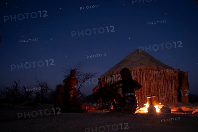Himba at the campfire in the evening, night view, Himba huts, traditional Himba village in the savanna, Kaokoveld, Kunene, Namibia
