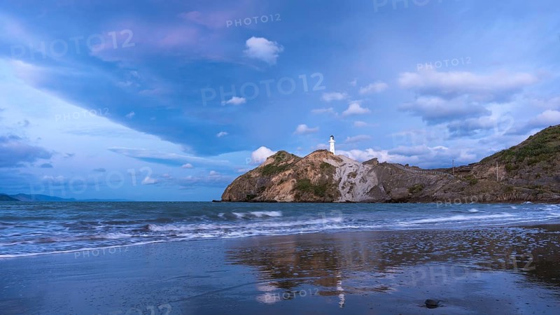 Castlepoint Beach, ocean and lighthouse on a rock, in the evening, after sunset. Castlepoint, Wairarapa Coast, Wellington Region, North Island, New Zealand