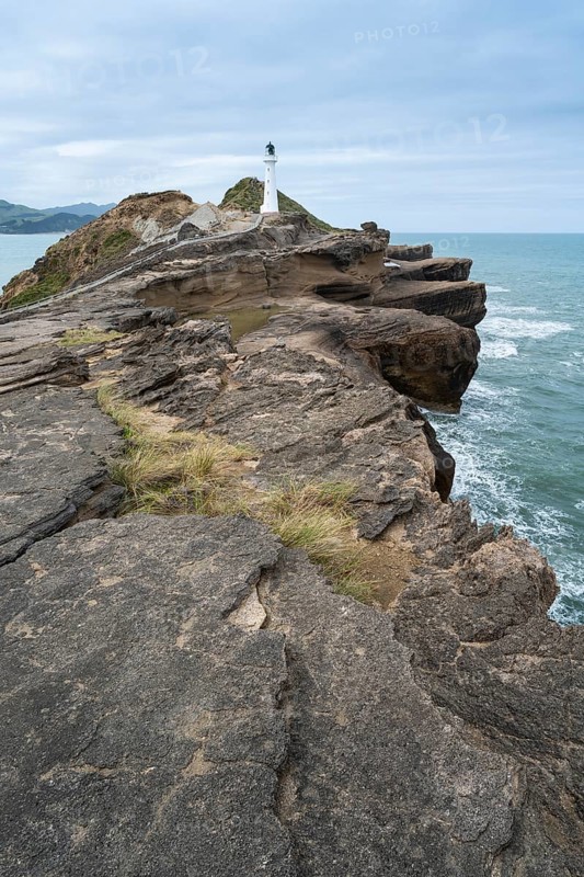 Castlepoint lighthouse on a rock, ocean. Castlepoint, Wairarapa Coast, Wellington Region, North Island, New Zealand