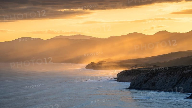 Wairarapa coast at sunset. Sea, mountains, backlight. Castlepoint, Wairarapa Coast, Wellington Region, North Island, New Zealand