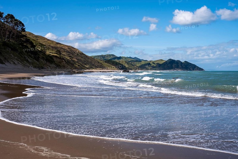 Castlepoint Beach, ocean, sandy beach, surf, mountains. Castlepoint, Wairarapa Coast, Wellington Region, North Island, New Zealand