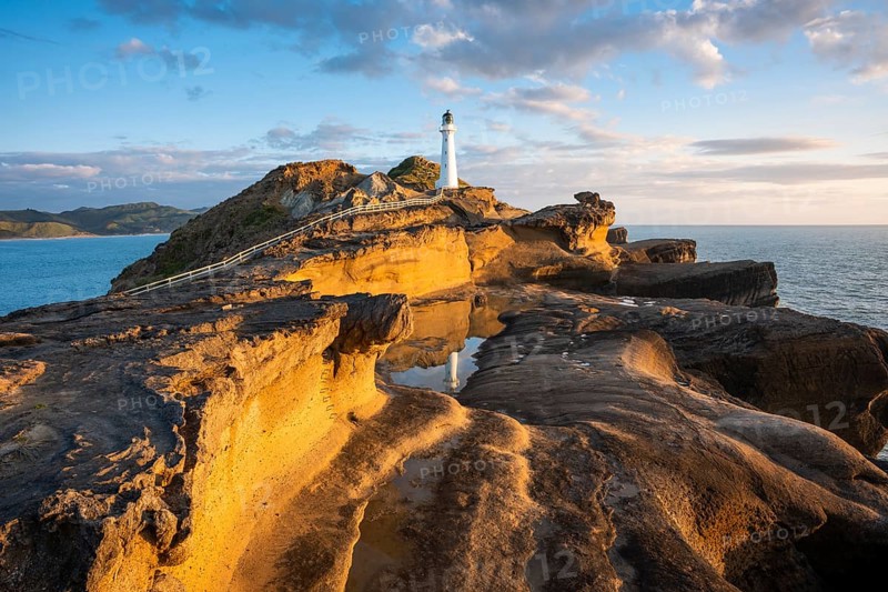 Castlepoint lighthouse on a rock, sea, sunrise. Castlepoint, Wairarapa Coast, Wellington Region, North Island, New Zealand