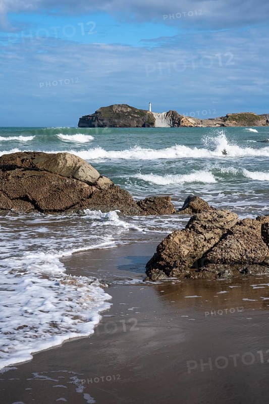 Castlepoint Beach and Castlepoint Lighthouse, ocean, waves, surf, sandy beach, rocks. Castlepoint, Wairarapa Coast, Wellington Region, North Island, New Zealand