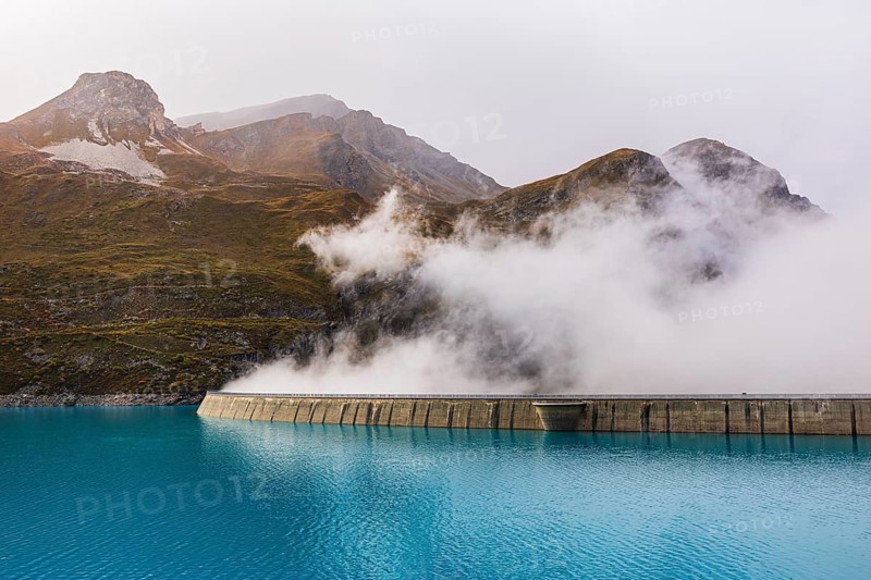 Fog rises over the dam of the Lac de Moiry Reservoir, Val d'Anniviers, Valais Alps, Canton of Valais, Switzerland