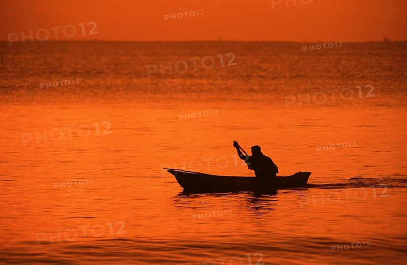Silhouette of a fisherman in his boat at sunrise near Mikadi Beach, Dar es-Salaam, Tanzania, Africa, June 2000, vintage, retro, old, historic