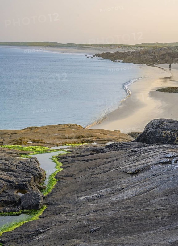 Granite rocks in the evening light and turquoise blue sea at Gurteen Beach, Roundstone, County Galway, Ireland