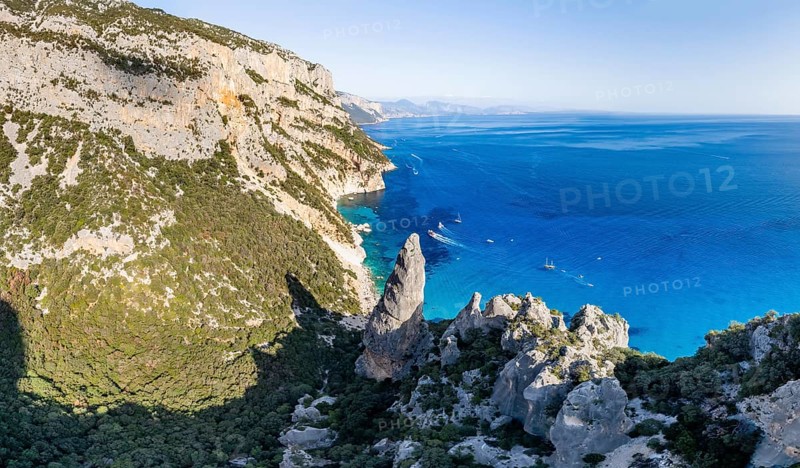 Picturesque rocky coast, cliffs with L'Aguglia pinnacle, blue sea and Cala Goloritzé beach, aerial view, Golfo di Orosei, Baunei, Sardinia, Italy