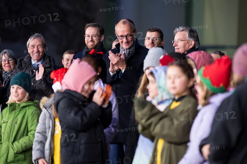 Friedrich Merz (CDU, Federal Chancellor of the Federal Republic of Germany) behind the Vocal Hero Children's Choir from Schöneberg elementary schools handing over the Christmas tree to the Federal Chancellery, Berlin, 28.11.2025